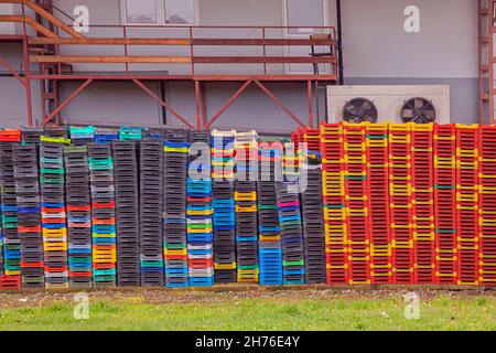 Large pile of colorful empty plastic crates in warehouse outdoors Stock Photo