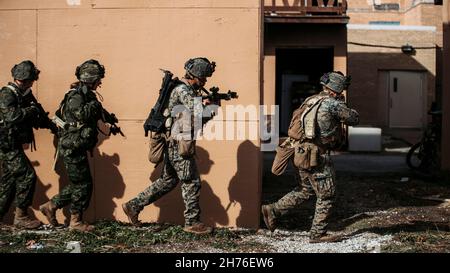 U.S. Marines with Mobility Assault Company, 2d Combat Engineer Battalion, 2d Marine Division, and Canadian Soldiers with 2 Combat Engineer Regiment, 2 Canadian Mechanized Brigade Group, 4th Canadian Division, patrol through an urban area during the final training event of Exercise Bold Quest 21.2 at Muscatatuck Urban Training Center, Ind., Nov. 16, 2021. The exercise is a joint and multinational operational assessment and demonstration to improve technical and procedural tactical-level sensor-to-shooter interoperability. (U.S. Marine Corps photo by Lance Cpl. Jacqueline C. Arre) Stock Photo