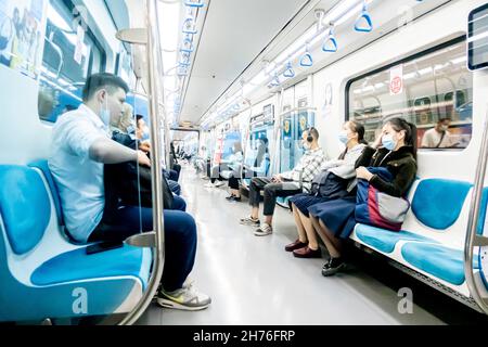 Passengers in face masks traveling commuting in car carriage in metro train riding in Almaty subway. Public transportation Almaty, Kazakhstan Stock Photo