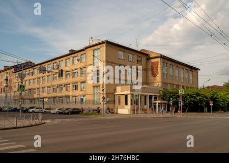 People walk to the pedestrian crossing past the Soviet-era Administrative Building at the corner of Karl Marx and Dekabristov streets in summer. Stock Photo