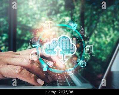 Cloud computing technology concept. Cloud icon virtual with data, security shield, document information symbols appeared while man using a laptop comp Stock Photo