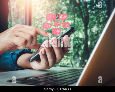 Social media and digital marketing with smartphone, social network lifestyle people concept. Pink speech bubbles with icons and numbers on mobile phon Stock Photo