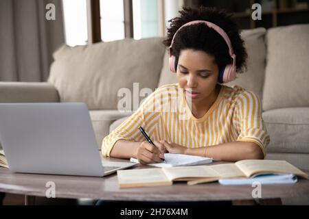 Serious young African Student girl in wireless headphones
