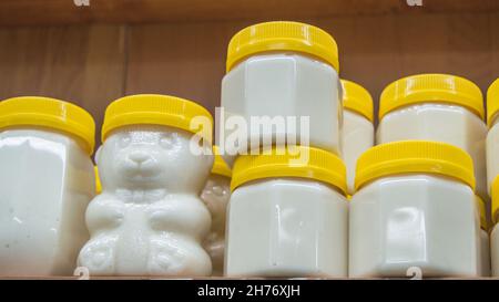 Natural honey in various jars on a wooden shelf, souvenir village market Stock Photo