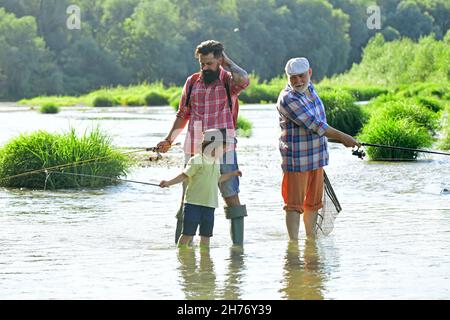 Hobby and sport activity. Men hobby. Summer weekend. Father teaching son how to fly-fish in river. Summer day. Anglers. Stock Photo