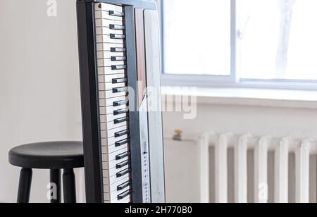 Piano keys in the interior of a bright room. Stock Photo