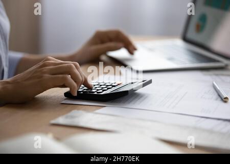 Close up view woman using laptop and calculator Stock Photo