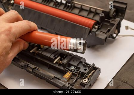 view of a worn out upper heating shaft, roller from a printer in the hand of a person Stock Photo