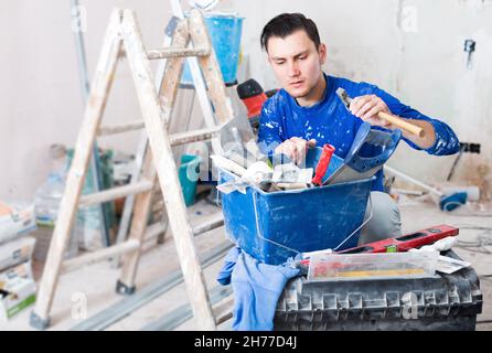 Handyman choosing necessary tool in toolbox Stock Photo