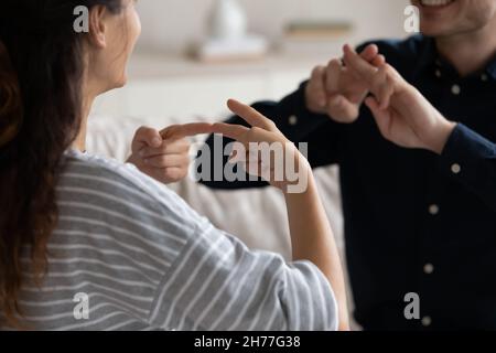 Couple communicating at home using sign language, closeup Stock Photo