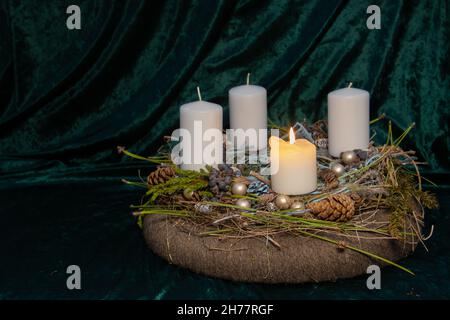 First Advent - self made Advent wreath with selective focus on foreground with one white candle burning, a tradition in the four weeks before Christma Stock Photo