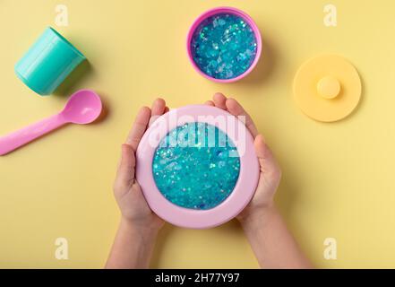 girl playing with blue slime and toy kitchenware Stock Photo