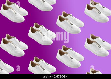 White sneakers pattern on a velvet violet background. The shoes are comfortable and casual. Background for a shoe store. A pair of new shoes. Stock Photo