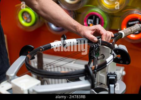 Process of stringing a tennis racket in a tennis shop, new tennis racket string, sport and leisure concept Stock Photo