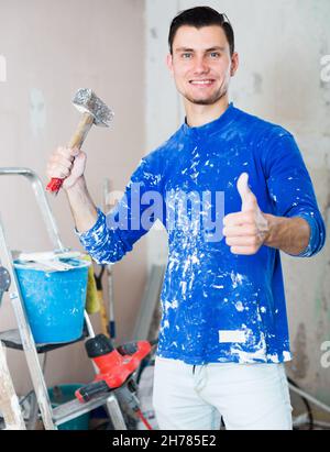 Smiling builder showing thumb up Stock Photo