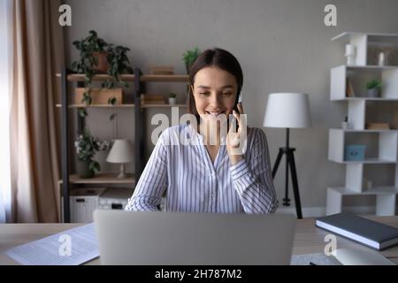 Smart female manager multitasking, working in modern office room. Stock Photo