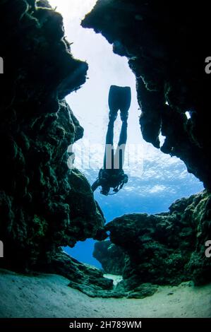 silhouette of a Divers exploring natural caves and rocks in the Mediterranean sea off the coast of Larnaca, Cyprus Stock Photo