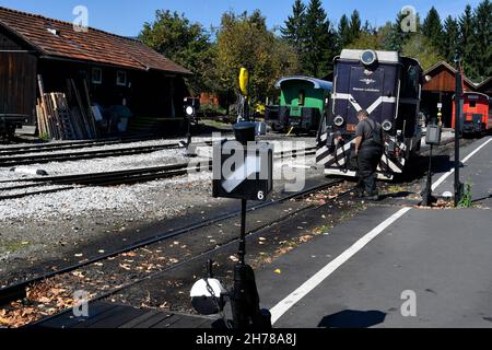 Stainz, Austria - September 23, 2021: Worker and diesel locomotive of the so-called Flascherlzug - bottle train - a narrow-gauge railway and a popular Stock Photo