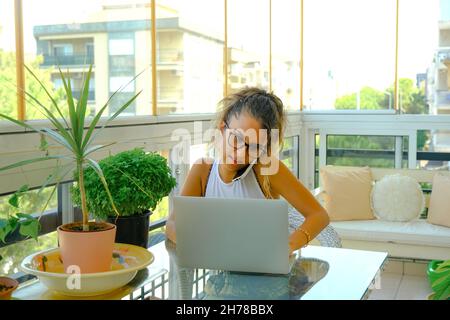 Young woman working from home on her laptop computer. Stock Photo