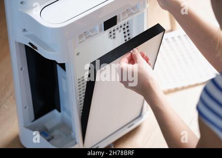 Woman changing the filter in the air purification system Stock Photo