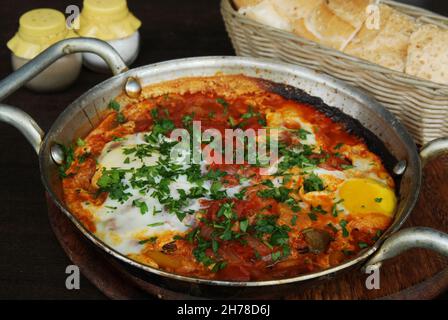 Shakshuka an Israeli dish made of cooked tomatoes, peppers, spices and eggs Stock Photo