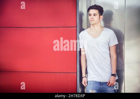 Attractive young man in city, standing, with white shirt Stock Photo