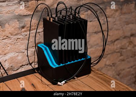 Many big portable phone chargers for charging phones stands inside a dock station on the table at restaurant. Portable. Useful. Electric. Electricity. Stock Photo