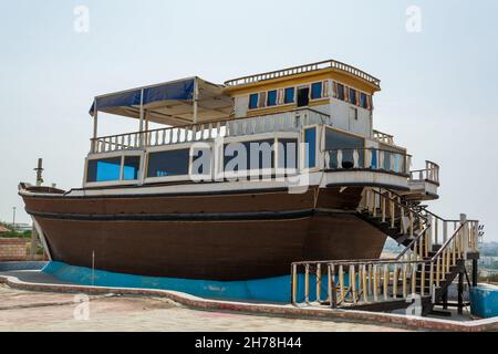 abandoned brown fishing boat on the ground in chabahar, a boat places on the ground for show, baluchistan province iran Stock Photo