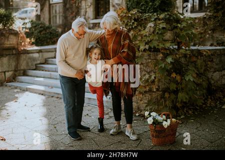 Grandparents enjoying good time with their cute little granddaughter Stock Photo