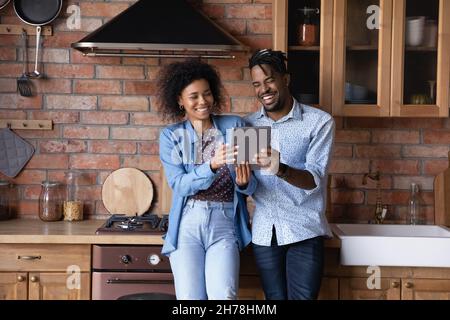 Happy young African American family couple using digital tablet. Stock Photo
