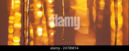 Panoramic close-up image of icicles lit by the low angle winter sunlight Stock Photo