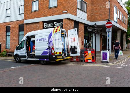 Woodbridge Suffolk UK August 08 2021: BT Openreach van parked in a town center street in Suffolk. An operative is working behind barriers on a network Stock Photo