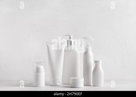 White jars, tubes and bottles cosmetic containers on white background, copy space. Bath skin care accessories. Face and body care concept. Stock Photo