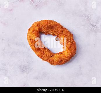 SIngle breaded onion ring on a marble surface Stock Photo