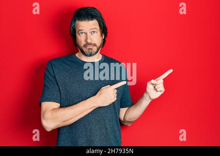 Middle age caucasian man pointing with fingers to the side depressed and worry for distress, crying angry and afraid. sad expression. Stock Photo