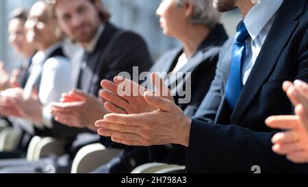 Business partners hands applauding at meeting, people sitting in a row at conference Stock Photo