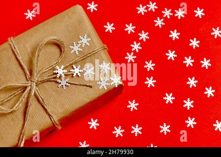gift eco box on red background with white snowflakes. merry christmas and new year present and greetings Stock Photo