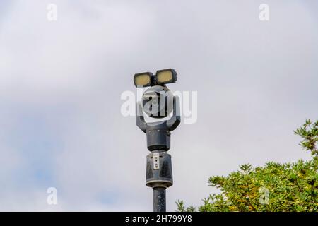 Moving security camera on a post with lights on top Stock Photo