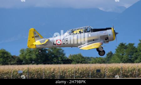 Udine Italy SEPTEMBER, 17, 2021 Old military airplane of WWII landing with mountains in the background. North American T-6 Texan or Harvard ex Italian Air Force Stock Photo