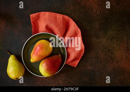 Plate with ripe pears on linen napkin, that background with space for text Stock Photo