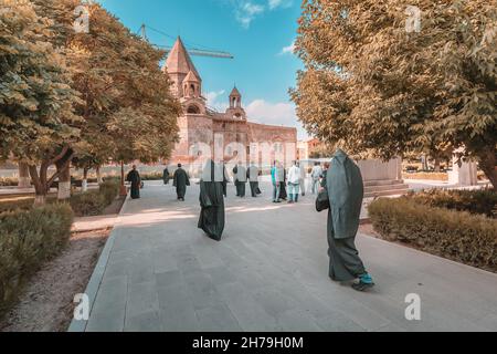 17 May 2021, Vagharshapat, Armenia: Many clergymen in robe and parishioners walking near Mother See of Holy Etchmiadzin Cathedral in the Etchmiadzin c Stock Photo