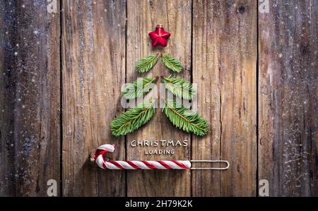 Christmas Loading Concept - Fir Tree And Candy Canes On Wooden Rustic Table Stock Photo
