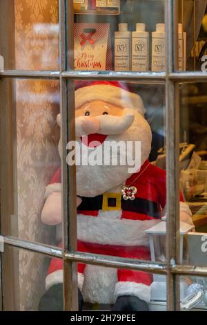 santa claus model in a shop window decorated for the xmas or festive season, father christmas manikin in shop display for the festive christmas season Stock Photo