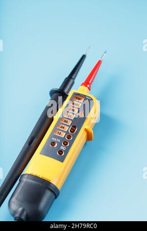 Two-pole voltage indicator with electrical drawings on a blue ...