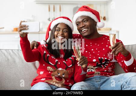 Happy black couple taking selfie while having New Year party Stock Photo