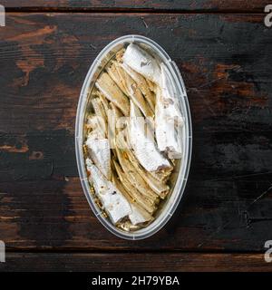 Canned Anchovy set, in plastic container, on old dark wooden table background, top view flat lay, square format Stock Photo