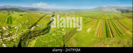 Panoramic view from the drone on the rows of agricultural land sown with crops and two rivers in deep canyons near the Lori Berd fortress in Armenia Stock Photo