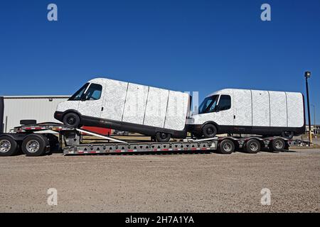 Two brand new model EDV 500 Rivian Electric Delivery Vans (EDV) part of the fleet order for Amazon on the back of a transportation lowboy truck parked in the Knights Inn Motel while  traveling from the production plant in Normal Illinois to their final destination Stock Photo