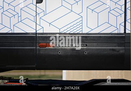 Two brand new model EDV 500 Rivian Electric Delivery Vans (EDV) part of the fleet order for Amazon on the back of a transportation lowboy truck parked in the Knights Inn Motel while  traveling from the production plant in Normal Illinois to their final destination Stock Photo