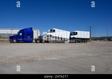 Two brand new model EDV 500 Rivian Electric Delivery Vans (EDV) part of the fleet order for Amazon on the back of a transportation lowboy truck parked in the Knights Inn Motel while  traveling from the production plant in Normal Illinois to their final destination Stock Photo